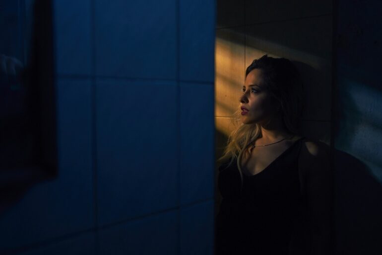 woman alone staring through a window