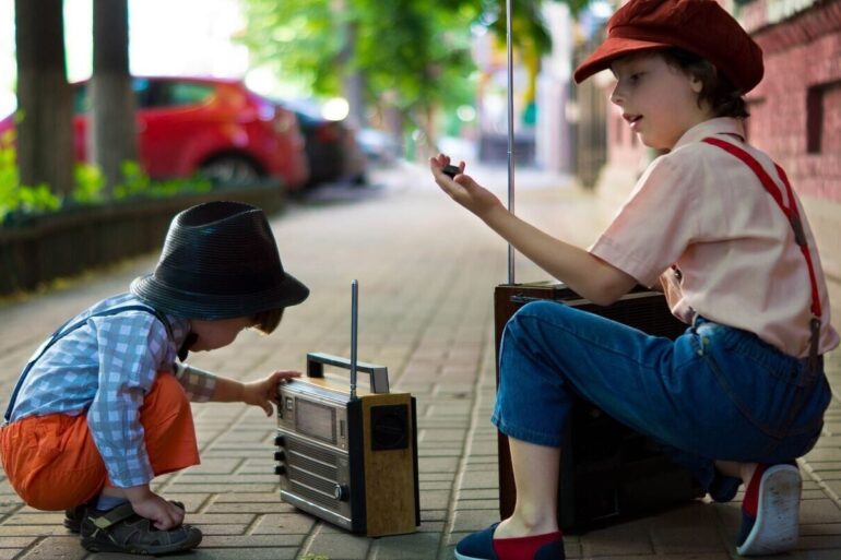 two boys playing with a radio