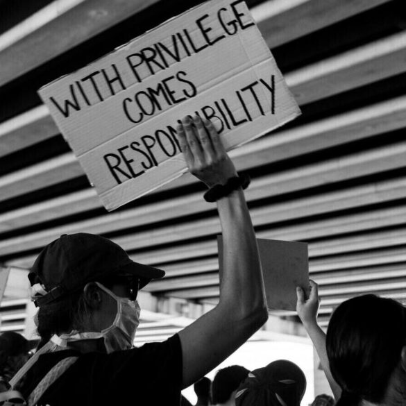 Crowd with sign with privilege comes responsibility