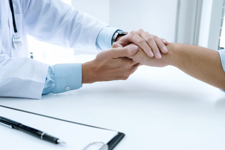 doctor holding patient's hand