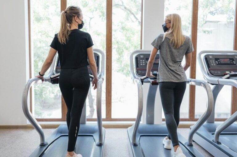 two women on treadmills in a gym