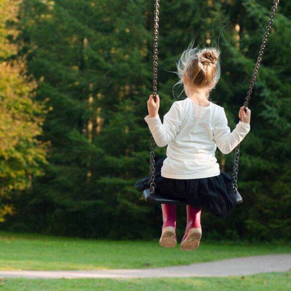 Little girl on swing outside