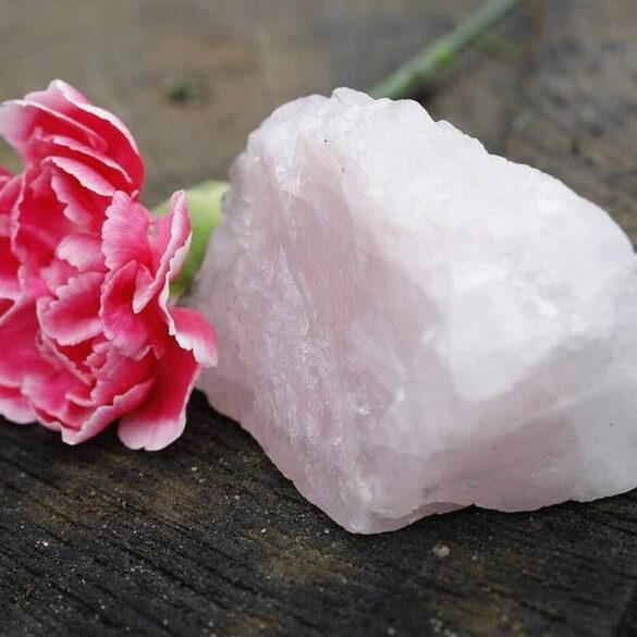 Pink rose next to light pink crystal