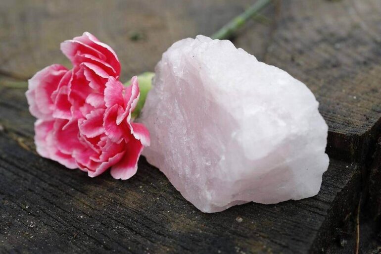 Pink rose next to light pink crystal