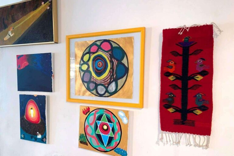 Six paintings displayed in Max Reif's hallway