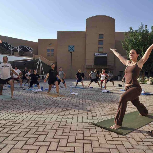 Men and women doing Yoga outdoors