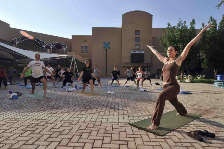 Men and women doing Yoga outdoors