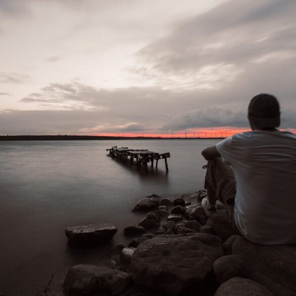 Man sitting calmly outdoors by water