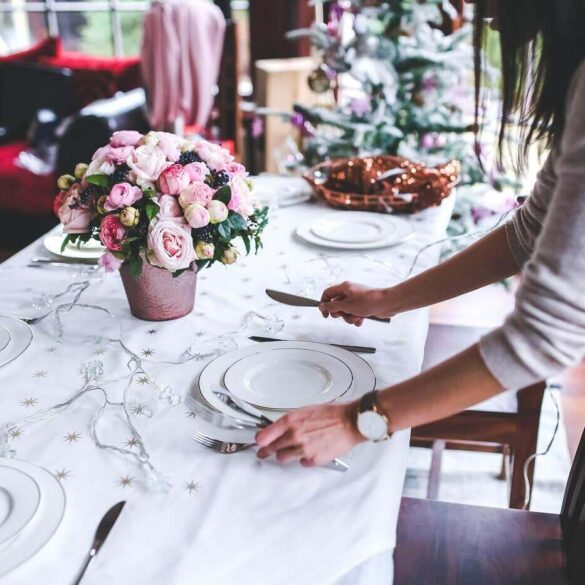 Woman setting table for holiday dinner