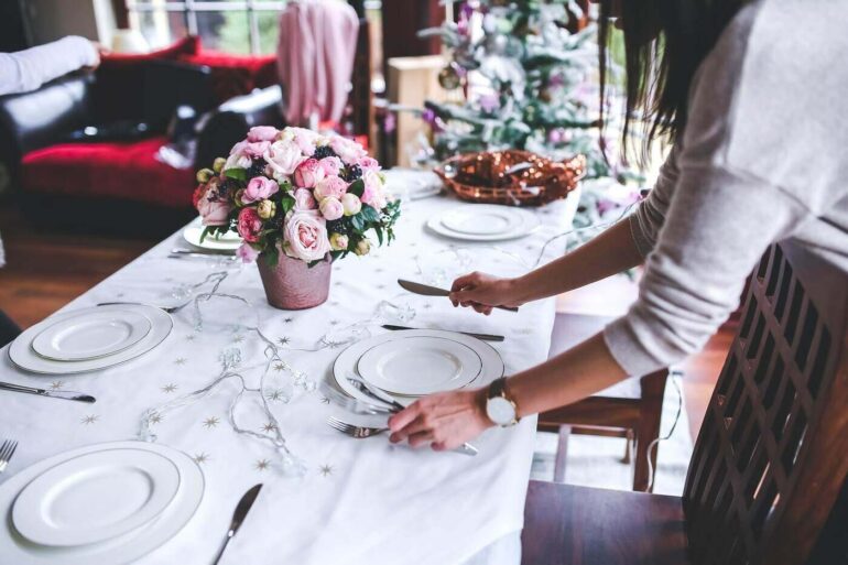 Woman setting table for holiday dinner