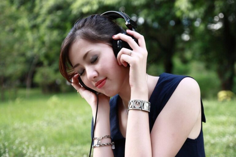 Woman listening to headphones outdoors