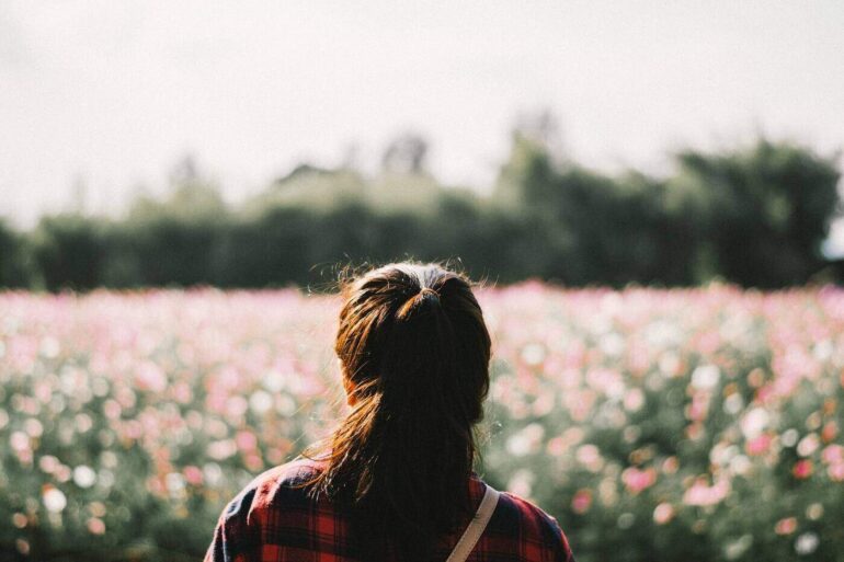 Woman looking at field of flowers