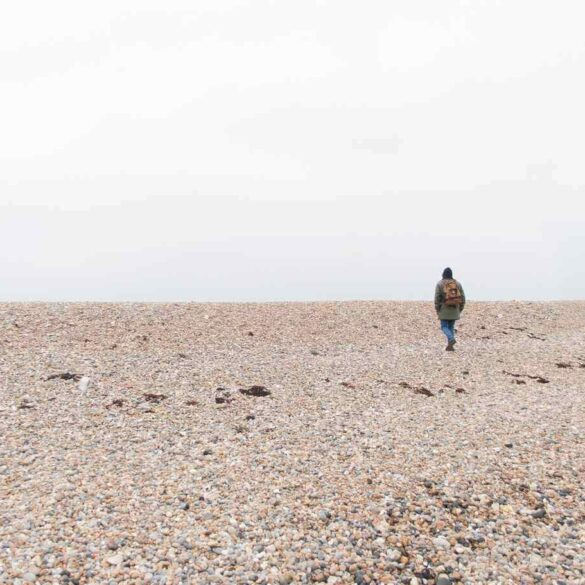Person walking on stony beach