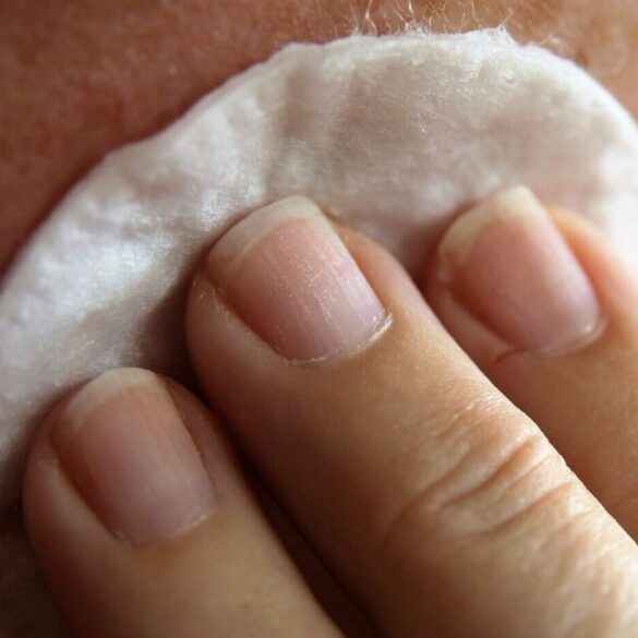 Person wiping face with soft skincare pad