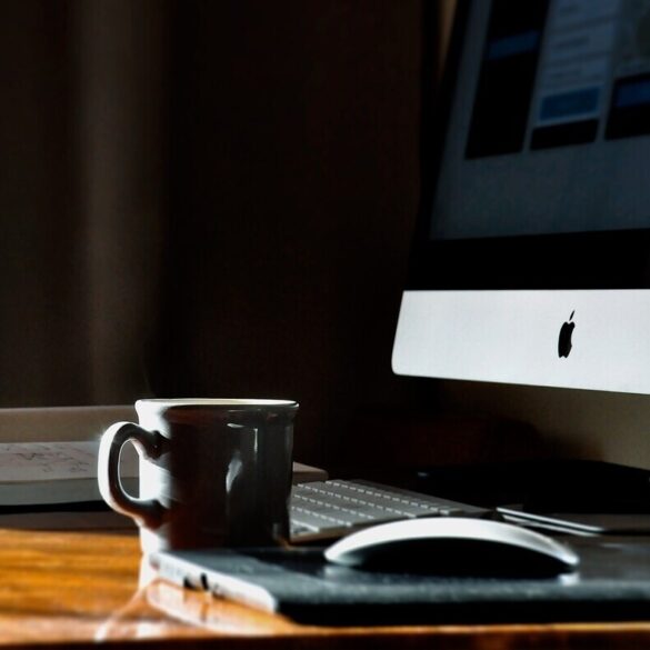 Coffee, computer and book on desk