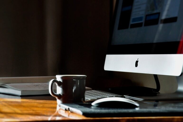 Coffee, computer and book on desk