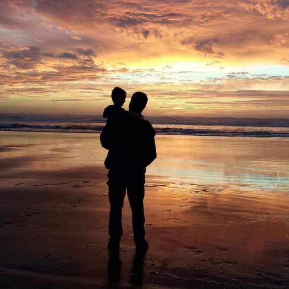 dad holding toddler at sunset