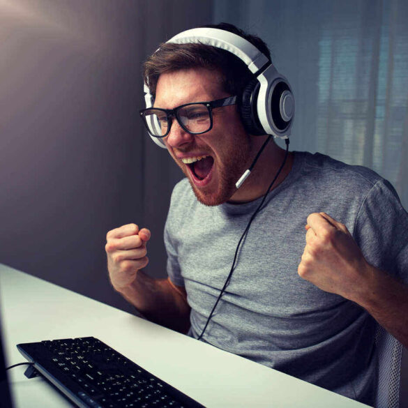 Man cheering in front of video game on computer