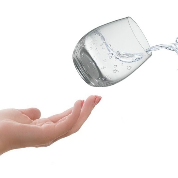 hand throwing a glass of water releasing a goldfish