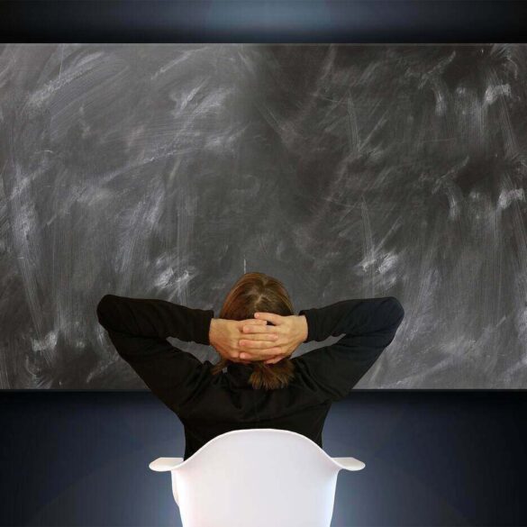 woman sitting in front of a blank blackboard