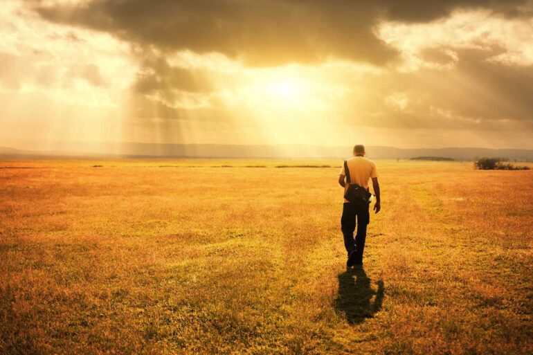 Man walking outdoors with rain cloud above