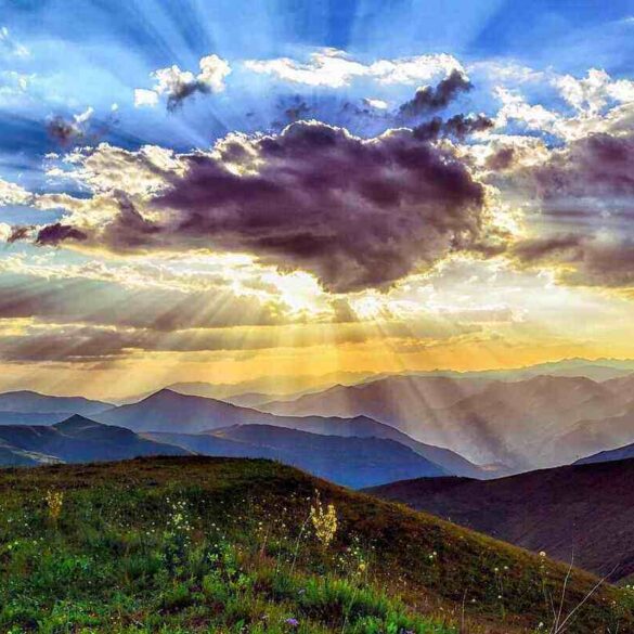 landscape with clouds with sun shining behind them