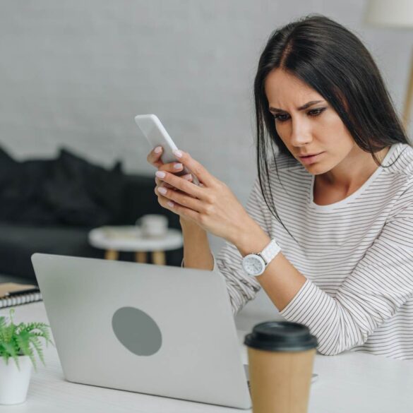 Stressed-out woman using laptop and smartphone