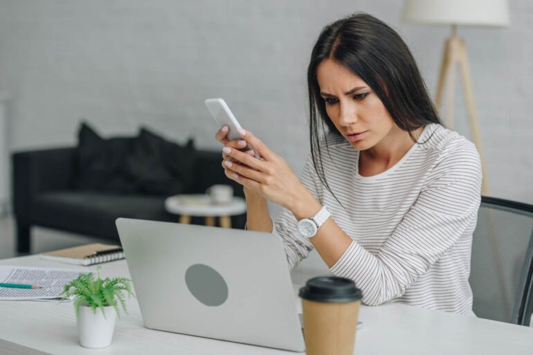Stressed-out woman using laptop and smartphone