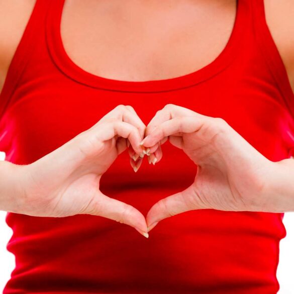 Person in tank top making heart shape with hands