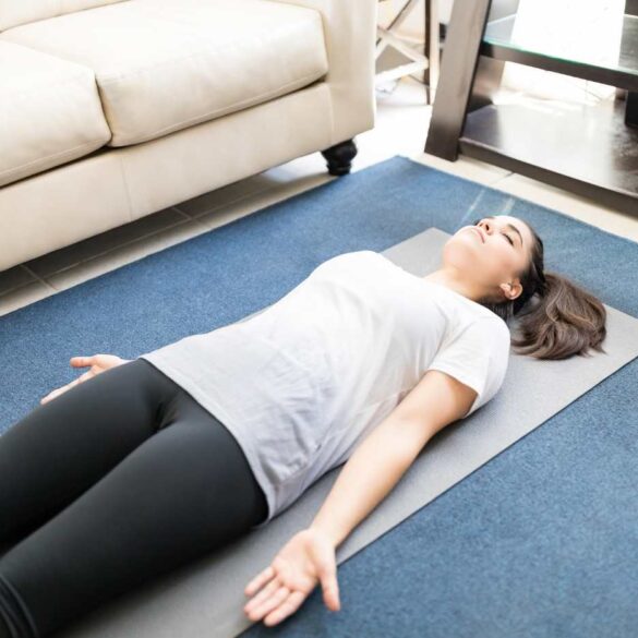 Woman lying in savasana on Yoga mat - Calm the biochemical storm