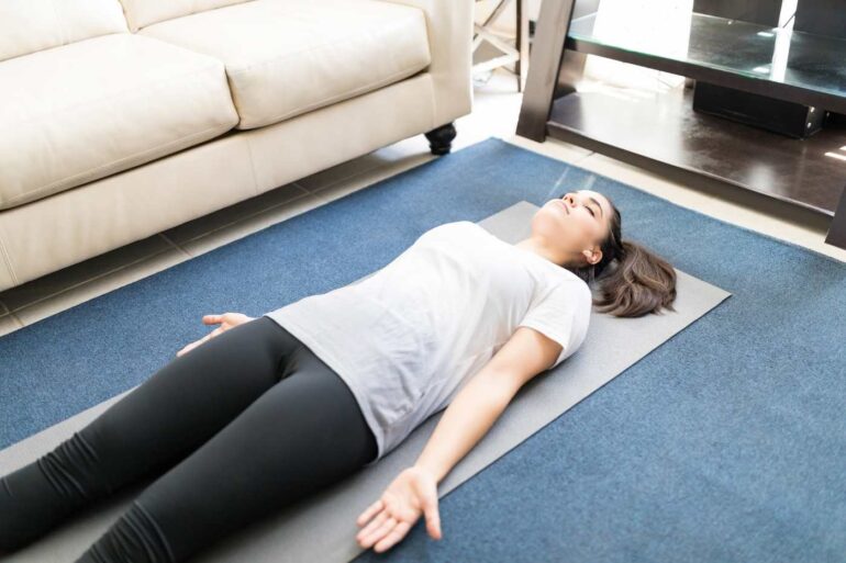 Woman lying in savasana on Yoga mat - Calm the biochemical storm