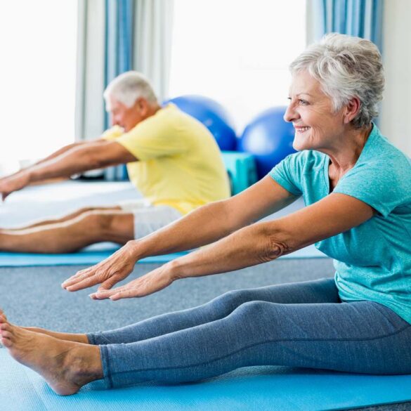 Two older adults doing Yoga stretches