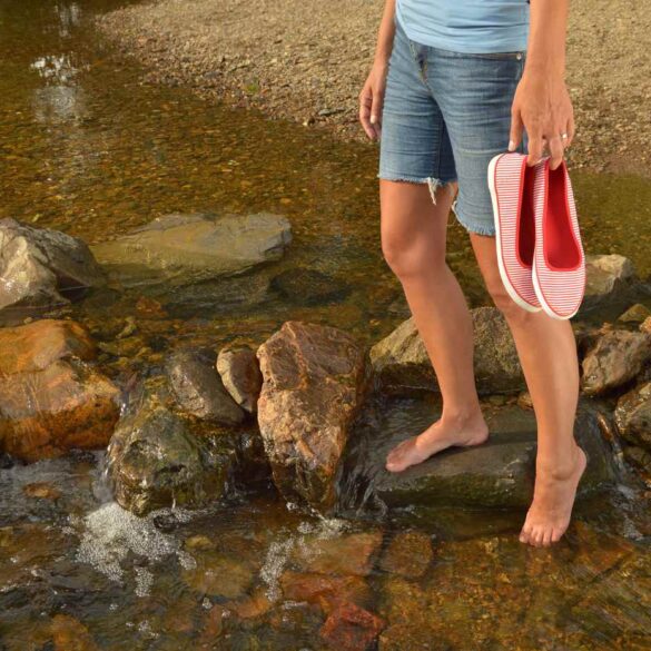 Young girl walking on rocks in river