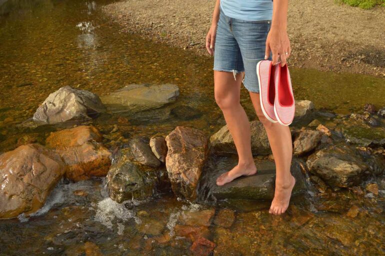 Young girl walking on rocks in river