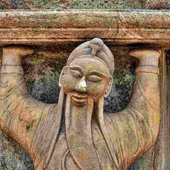statue of monk holding up a lintel