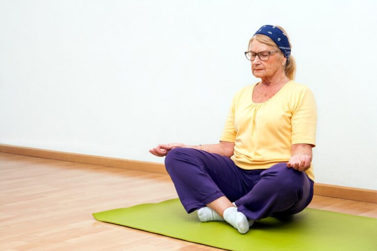 Senior woman meditating on Yoga mat - Gratitude: 3 Ways to Cultivate It While Aging Mindfully