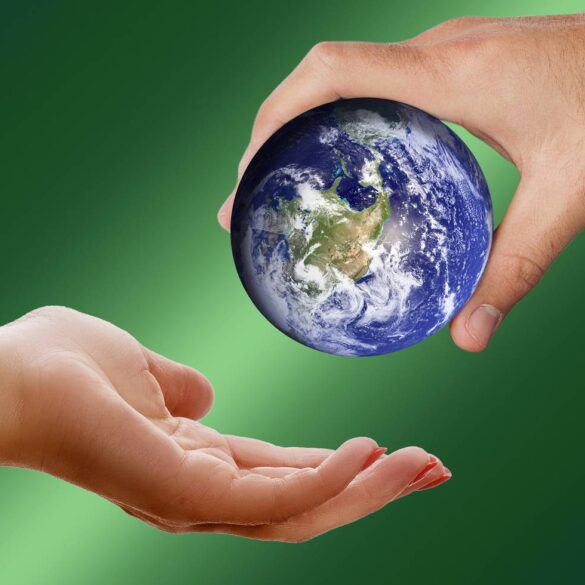 Older hand hanging planet Earth to younger hand