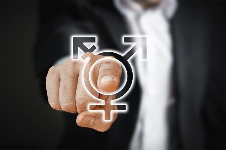 man in suit point to a 'gender' sign - Beyond the Gender Debate: A Slippery Slope of Self-Identification