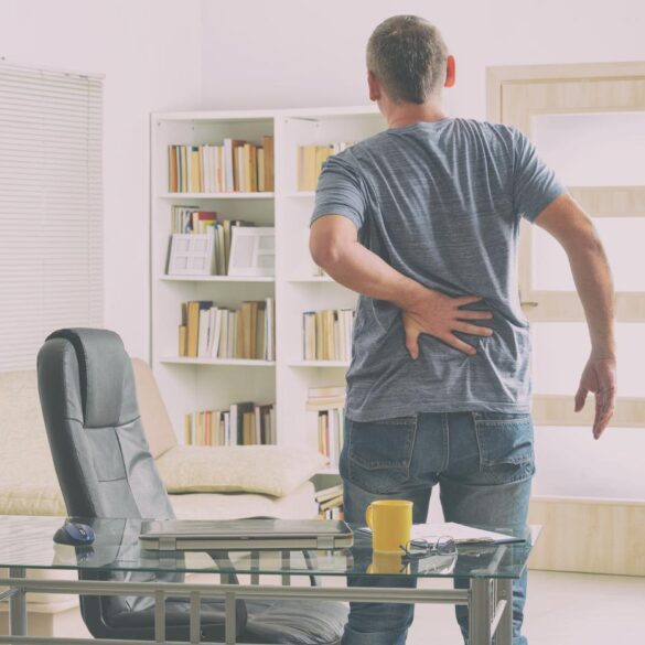 Man with back pain getting up from desk