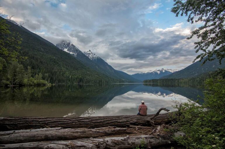 Man sitting on log beside lake - 3 Poems About Mindful Living, Including "To-Do List"