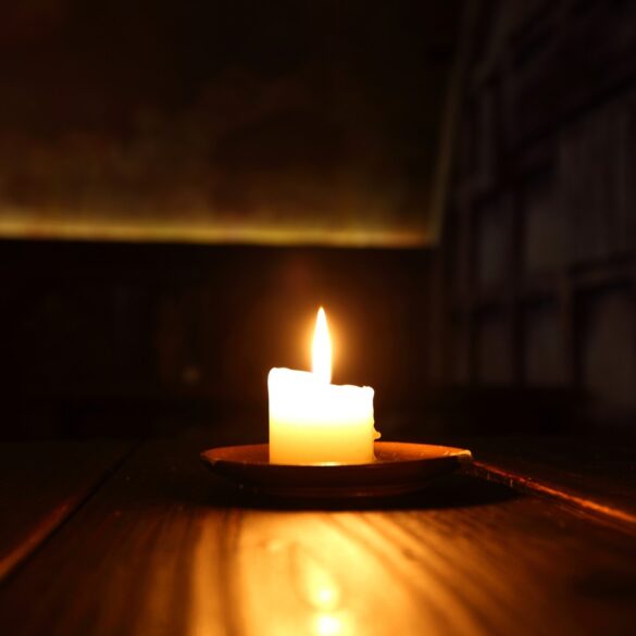 Lit candle in dark room - 5 Effective Ways of Coping With Shame Due to Addiction