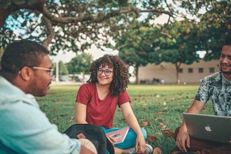 two male and one female student on college lawn - Eliminating Racial Preferences: Will It Benefit Wealthy Students?
