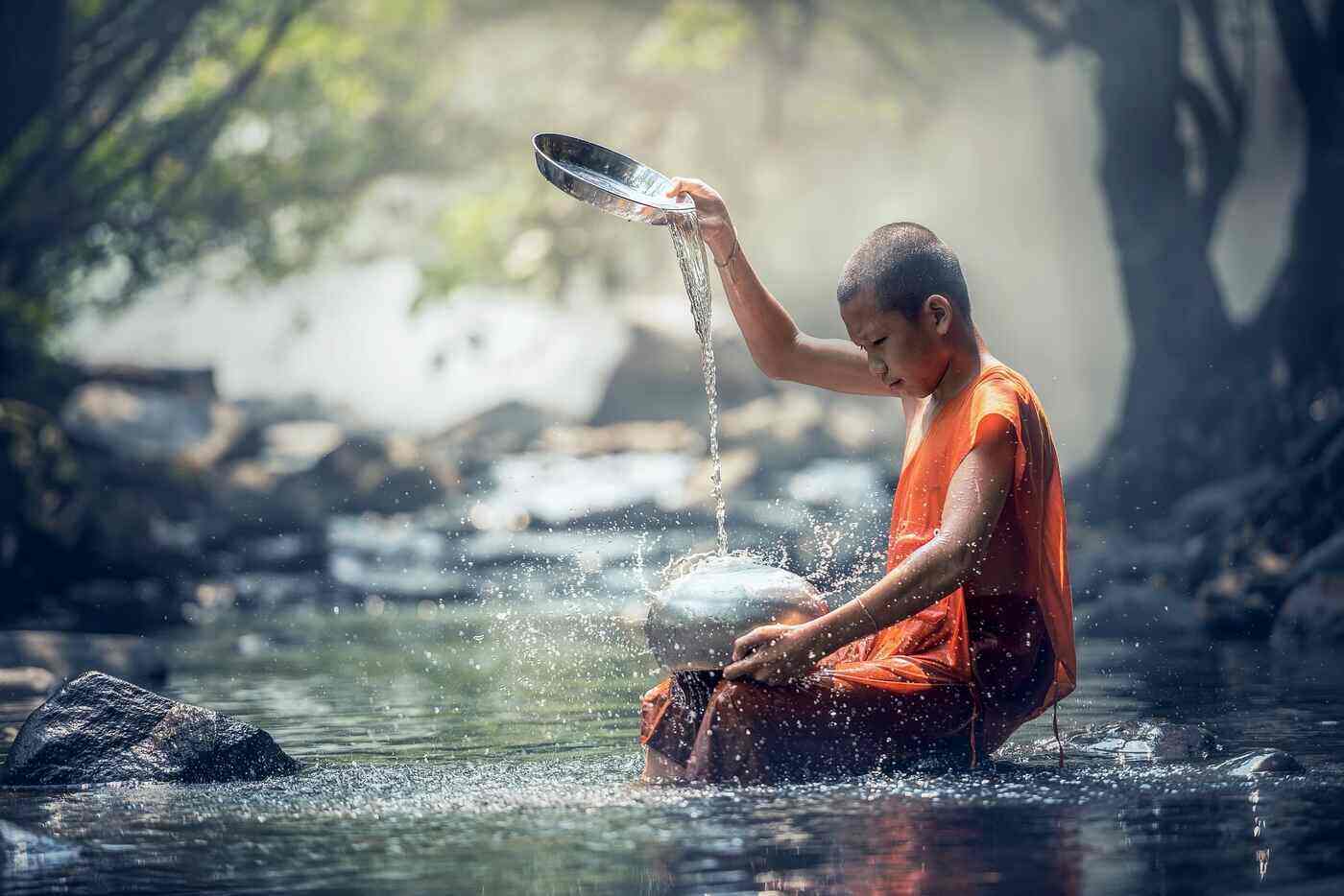 TOO BUSY TO BE SPIRITUAL: 9 mini-rituals you can do anywhere 13 Young boy sitting in a stream, trickling water from a bowl - Spiritual Rituals For Busy People: 9 Mini-Rituals to Do Anywhere