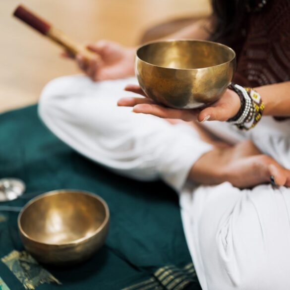 Person meditating with sound healing bowls - Insight Timer App: A Universal Hub for Meditation Practice