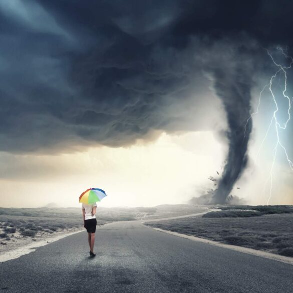 Woman walking in storm with rainbow umbrella - Overcome Every Storm in Life With Love and Gratitude