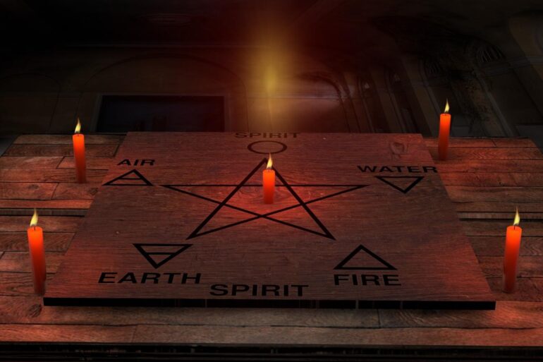 Candles next to the five elements (earth, fire, water, air, spirit) on a pentagram - Bewitching the Elements: A guide to living a witchy life