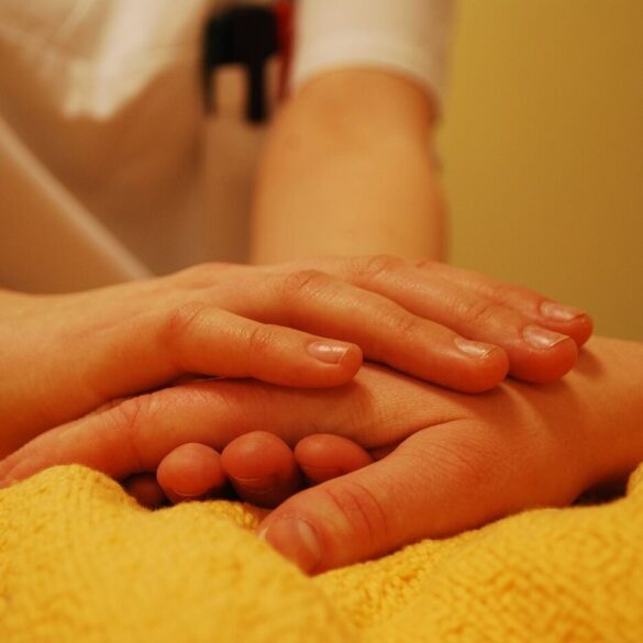 Comforting hand holding for a sick person in bed - We Need Each Other: Lessons Learned While Living With COVID