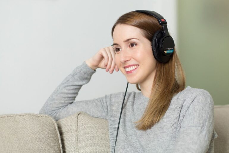 Happy woman listening to headphones - Heal From Trauma: 5 Tips to Help You Start Your Healing Journey