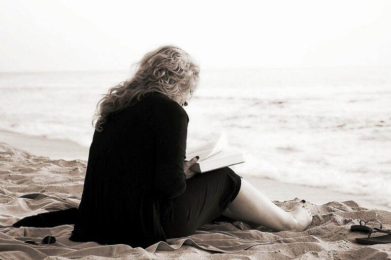 Woman reading book on beach - Use Mindfulness to Seek a Stable Mind and Meaning in Life