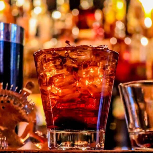 Manhattan cocktail with two other drinks on a bar - Numbing the Pain: Addiction Isn’t a Question of Willpower